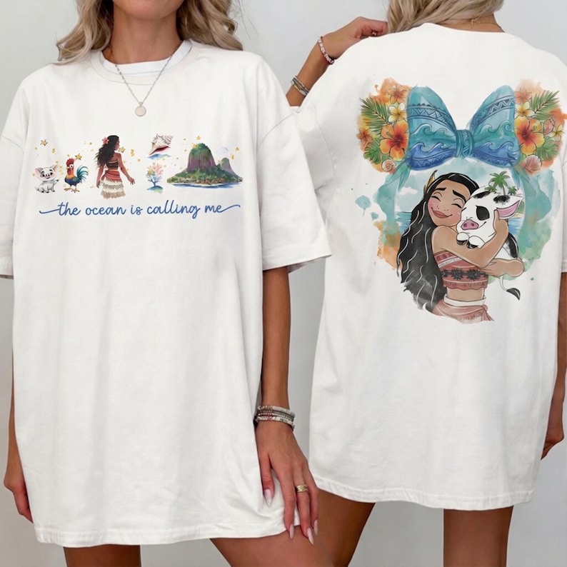 May include: White t-shirt featuring a colorful illustration of a Polynesian woman, a pig, and tropical elements. The front of the shirt has the text "the ocean is calling me". The back of the shirt has a large graphic of a woman hugging a pig.