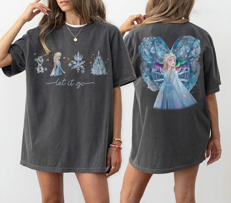May include: Dark gray t-shirts with a watercolor design featuring a princess, snowflakes, and a castle. The front of the shirt has the text "Let it go". The back of the shirt has a large image of the princess.
