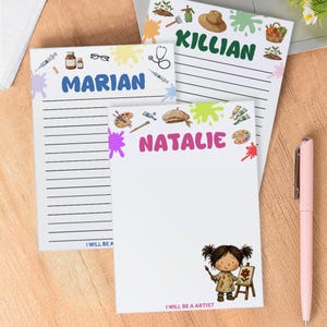 May include: Three personalized notepads with names: Marian, Natalie, and Killian. Each notepad features a different profession-themed design, including medical, art, and gardening. The notepad for Natalie has a drawing of a girl with a paintbrush and the text "I will be an artist".