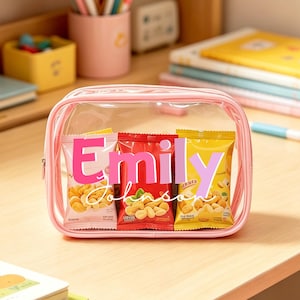May include: A rectangular, clear plastic pencil case with light pink trim. Inside, three snack-sized bags of nuts are visible, arranged side-by-side. The name "Emily Johnson" is printed in large, bold pink and light purple letters across the front.