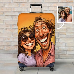 May include: A rolling suitcase featuring a vibrant orange cover with a cartoon-style caricature of a smiling couple. The woman wears dark sunglasses and a light purple shirt, while the man has curly hair and a pink shirt. A small photo inset shows the couple.
