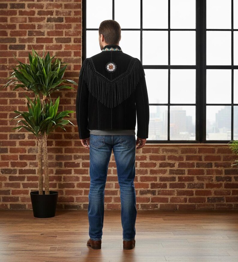May include: A black jacket featuring long fringe detailing across the back and shoulders, a high collar with intricate beadwork, and a circular beaded emblem centred on the upper back, paired with blue denim jeans.