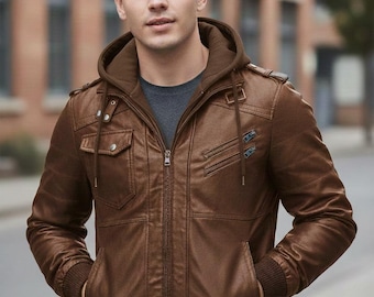 May include: A brown faux leather bomber jacket featuring a dark brown integrated hood with drawstrings, a full-length front zipper, two chest pockets with snap closures, two slanted zippered chest pockets, and ribbed cuffs and hem.