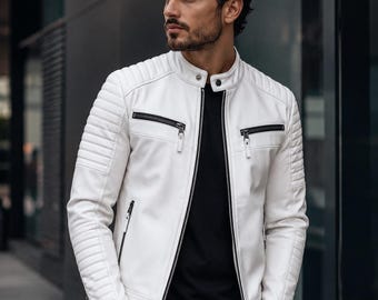 May include: A white leather jacket with black zips and quilted shoulder and arm detailing. The jacket features a stand-up collar and a tailored fit. The model is wearing a black top and black trousers.