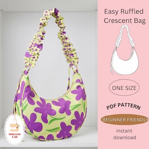 Può includere: Borsa a mezzaluna con motivo floreale viola e verde. La tracolla è arricciata. L'immagine include il testo "Easy Ruffled Crescent Bag", "ONE SIZE", "PDF PATTERN" e "BEGINNER FRIENDLY".