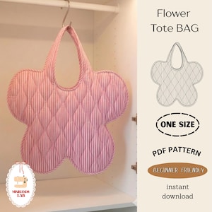 Op de afbeelding: Een roze bloemvormige draagtas met verticaal gestreepte quilting, hangend in een witte kast. De tas heeft een handvat en een uniek bloemenontwerp. Tekst op de afbeelding luidt "Flower Tote BAG", "ONE SIZE", "PDF PATTERN" en "BEGINNER FRIENDLY".