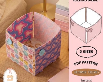 Peut inclure: Un panier pliable origami carré avec un design coloré. Le panier présente un motif de smiley d'un côté et un motif floral de l'autre. Il est maintenu par deux boutons bleu clair. L'image comprend également le texte "Origami 5-Square Folding Basket".