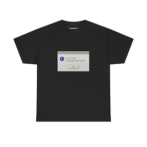 May include: Black t-shirt with a computer error message printed on the front. The message says "Error 404: costume not found" within a simulated window, with an "OK" button. The shirt has a crew neck and short sleeves.
