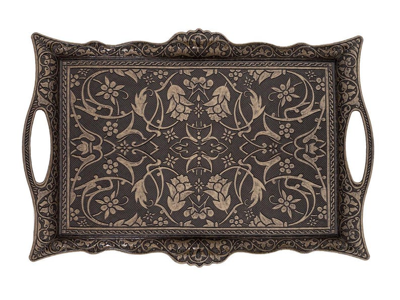Pode incluir: Bandeja decorativa retangular com padr&atilde;o floral e de folhas ornamentado em cor bronze escuro. A bandeja tem al&ccedil;as integradas e uma borda detalhada. A superf&iacute;cie apresenta um design floral repetido.