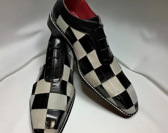 May include: A pair of black and white checkered dress shoes with black laces. The shoes have a glossy finish on the black squares and a matte finish on the white squares. The interior lining is red.