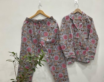 May include: A matching pyjama set with a button-down shirt and trousers. The set is grey with a floral pattern in pink and brown. The shirt has white trim and a breast pocket. The trousers have a drawstring waist.