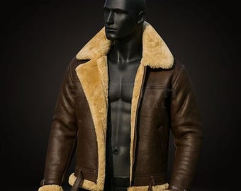 Può includere: Giacca in pelle marrone con colletto e fodera in montone beige. La giacca presenta vita e polsini con fibbia ed è esposta su un manichino nero. Classico stile aviatore.