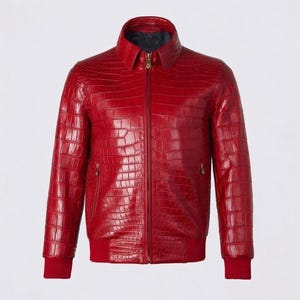 May include: A vibrant red leather jacket with a textured, crocodile-like pattern. The jacket features a collared neckline, a full-length zipper, and ribbed cuffs and hem. The jacket has two side pockets and a dark lining.