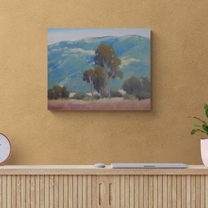 May include: A painting of a landscape with a group of trees in the foreground and rolling hills in the background. The sky is a light blue and the hills are a muted green and blue.