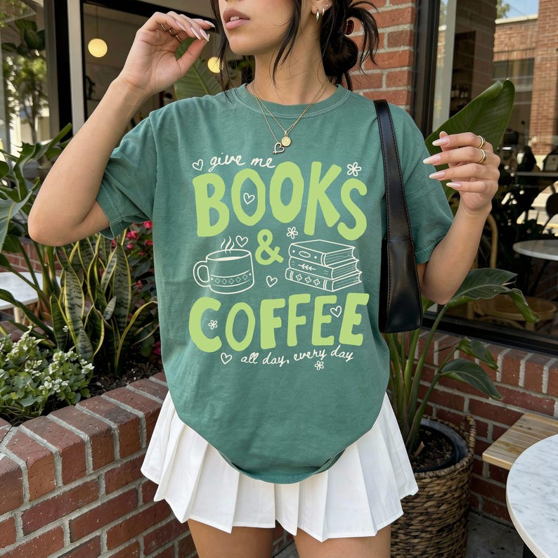 Books and coffee t-shirt design with the phrase give me books and coffee all day every day, featuring a coffee mug, stacked books and six design color options.