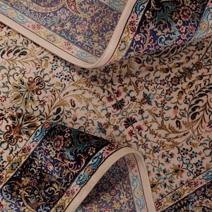 Peut inclure: Tapis de sol orné et enroulé, avec un fond crème et des motifs floraux complexes dans les tons de bleu, rouge et vert. Le tapis présente une bordure bleu foncé avec des motifs cachemire et floraux, créant une esthétique luxueuse.