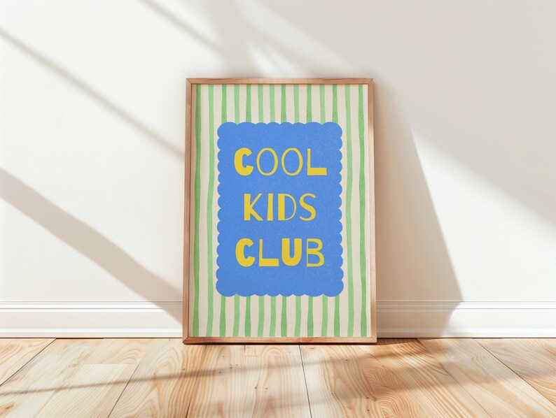 K&ouml;nnte beinhalten: Ein gerahmter Druck mit den Worten "COOL KIDS CLUB" in Gelb auf einem blauen, wellenf&ouml;rmigen Hintergrund. Der Hintergrund hat vertikale gr&uuml;ne und wei&szlig;e Streifen. Der Rahmen ist hellbraun. Der Druck lehnt an einer wei&szlig;en Wand auf einem Holzboden.
