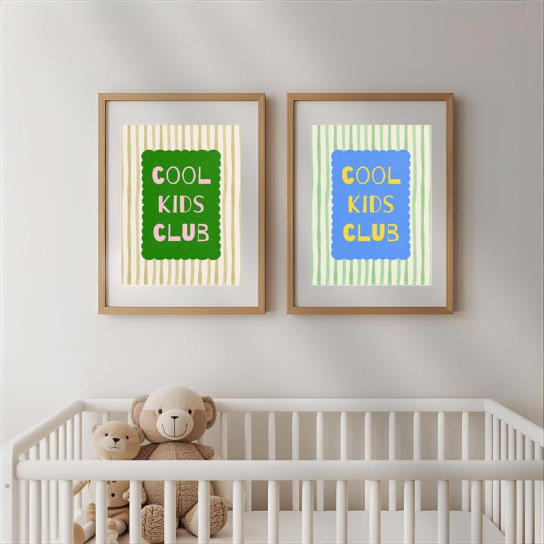 K&ouml;nnte beinhalten: Zwei gerahmte Drucke mit dem Text "COOL KIDS CLUB" in Gr&uuml;n und Blau, vor gestreiften Hintergr&uuml;nden. Die Drucke befinden sich &uuml;ber einem wei&szlig;en Kinderbett mit Teddyb&auml;ren.