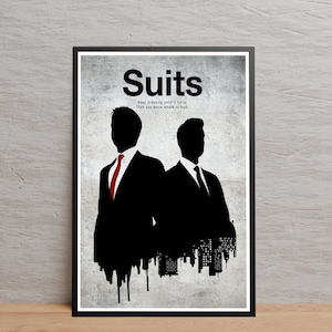 May include: A framed poster featuring the word "Suits" in bold black letters. Below the title is the quote, "Keep pressing until it hurts. Then you know where to look." Silhouetted figures of two men in suits are depicted, one with a red tie.