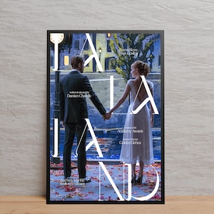 Puede incluir: Un póster enmarcado de la película "La La Land" con Emma Stone y Ryan Gosling tomados de la mano. El póster tiene un marco negro e incluye texto como "escrito y dirigido por Damien Chazelle" y "Y aquí está para los tontos que sueñan."