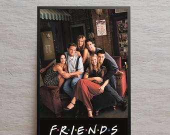 Peut inclure: Une affiche encadrée représentant les acteurs de la série télévisée "Friends" assis sur un canapé marron. Le logo de l'émission, "FRIENDS" en blanc avec des points colorés, est en bas. Le fond montre un café.