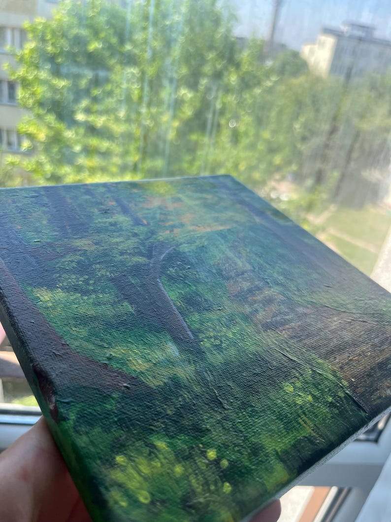 Op de afbeelding: Een vierkant canvas schilderij met een boslandschap met diepgroen gebladerte, donkerbruine boomstammen en gevlekt licht dat door het bladerdak filtert. De textuur van de verf zorgt voor een gelaagd effect op het oppervlak van het kunstwerk.