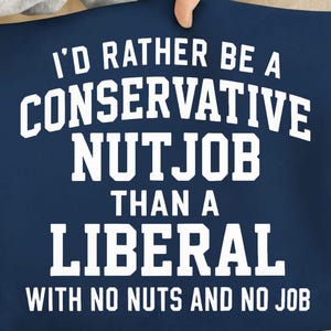 May include: Navy blue textile with white text. The text reads "I'D RATHER BE A CONSERVATIVE NUTJOB THAN A LIBERAL WITH NO NUTS AND NO JOB."