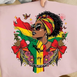 Peut inclure: Un t-shirt rose pâle avec une illustration graphique d'une personne aux cheveux noirs bouclés portant un foulard rouge, jaune et vert et des lunettes de soleil. Un poing levé, une chaîne, des nœuds rouges, des fleurs et des papillons figurent.