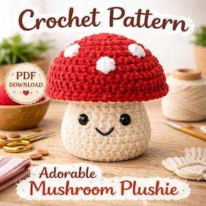 Puede incluir: Un peluche de hongo tejido a crochet con una gorra roja y manchas blancas, y un tallo color crema. El hongo tiene una cara sonriente con ojos negros y una boca curva. Se muestran las palabras "Crochet Pattern" y "Adorable Mushroom Plushie".