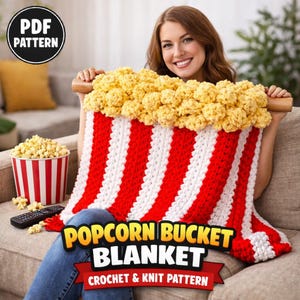 May include: A red and white striped popcorn bucket blanket with a yellow popcorn top. The blanket has the text "Popcorn Bucket Blanket Crochet & Knit Pattern". A PDF pattern is available.