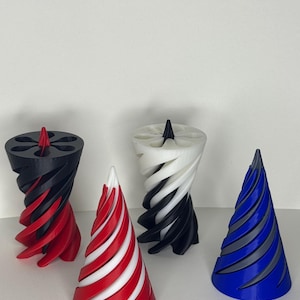 Könnte beinhalten: Vier dekorative 3D-gedruckte Objekte mit Spiraldesign. Die Objekte sind konisch geformt und haben eine strukturierte Oberfläche. Die Farben sind Schwarz und Rot, Weiß und Schwarz, Rot und Weiß sowie Blau und Grau.