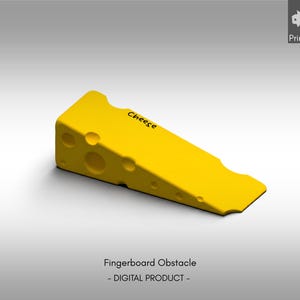 May include: A bright yellow wedge-shaped fingerboard obstacle designed to resemble a block of Swiss cheese, featuring several circular holes of varying sizes on its side and the word Cheese printed in black text on the top surface.