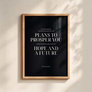 Puede incluir: Un cuadro rectangular en un marco de madera clara con fondo negro y texto blanco con serifa que dice: For I know the plans I have for you, declares the Lord, PLANS TO PROSPER YOU and not to harm you, plans to give you HOPE AND A FUTURE, JEREMIAH 29:11.