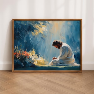 Può includere: Una stampa artistica da parete incorniciata che raffigura una figura con capelli lunghi e barba, che indossa una veste bianca, inginocchiata in preghiera. La scena presenta uno sfondo pittorico blu e giallo con raggi di luce e fiori arancioni.