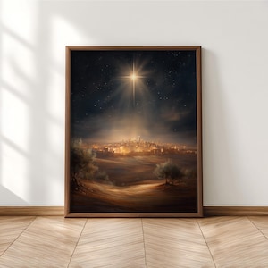 Op de afbeelding: Een ingelijste kunstdruk met een nachtscène. Een heldere ster schijnt over een stad. Het kunstwerk is gevat in een bruine houten lijst. De nachthemel is donker en vol sterren, wat een dramatisch beeld creëert.