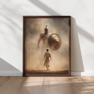Puede incluir: Obra de arte enmarcada que representa una escena bíblica. Un guerrero gigante con un escudo y una lanza se enfrenta a una figura más pequeña con una túnica blanca. La obra está en un marco marrón, contra una pared blanca y un suelo de madera.