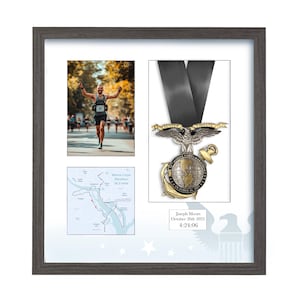 Può includere: Esposizione incorniciata con un corridore, una medaglia della Maratona dei Marine Corps e una mappa del percorso. La medaglia presenta un design a globo e le parole "Semper Fidelis". La cornice grigio scuro ha uno sfondo bianco e una silhouette di aquila.