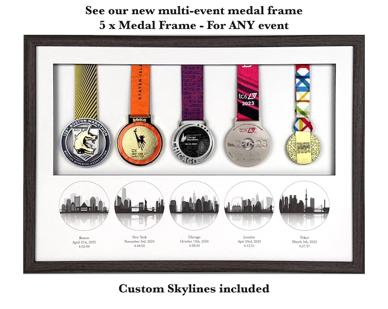 Puede incluir: Un marco rectangular de madera oscura que contiene cinco medallas de marat&oacute;n colgantes con cintas de colores. Debajo de las medallas hay cinco ilustraciones circulares en blanco y negro de horizontes urbanos etiquetadas como Boston, Nueva York, Chicago, Londres y Tokio.
