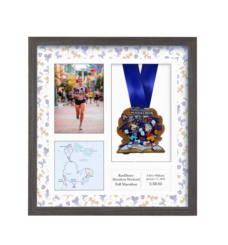 May include: Framed display featuring a marathon medal, a runner, and a race map. The medal has a blue ribbon and a colorful design. The frame is gray with a patterned border. The text on the frame reads "RunDisney Marathon Weekend Full Marathon".