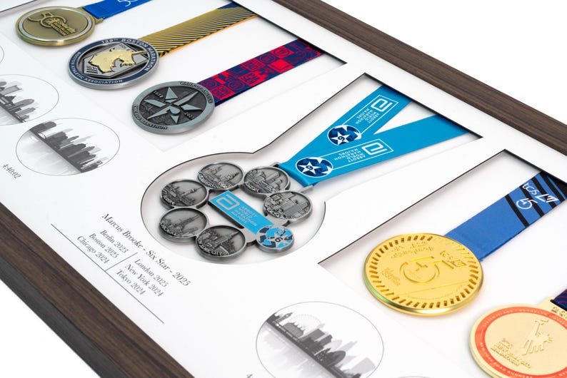 May include: A wooden display frame containing multiple marathon medals with colorful ribbons. The center features a Six Star medal with a blue ribbon. Text on the white mat board reads: Marcus Brooke - Six Star - 2025, Berlin 2025, Boston 2025, Chicago 2024, London 2025, New York 2024, Tokyo 2024.