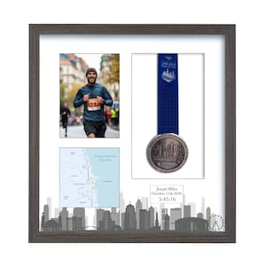 Puede incluir: Un marco cuadrado de color gris oscuro que contiene una foto de un corredor, una medalla del marat&oacute;n de Chicago con cinta azul, un mapa de la ruta de 26,2 millas y una placa blanca con el texto Joseph Miller, October 11th 2026, 5:45:16.