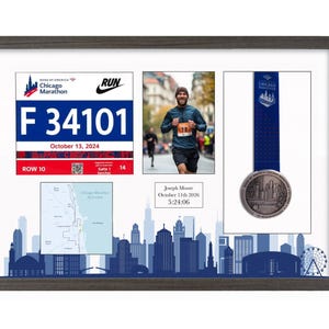 May include: A dark wood-framed display case featuring a Chicago Marathon race bib with the number F 34101, a photograph of a runner, a finisher medal with a blue ribbon, a course map, and a plaque reading Joseph Moore, October 11th 2026, 5:24:06.