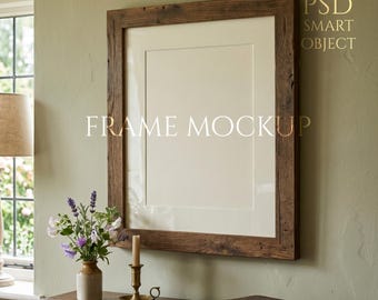 Könnte beinhalten: Ein großer, rechteckiger Holzrahmen-Mockup mit weißem Passepartout, der an einer hellgrünen Wand hängt. Der Rahmen besteht aus rustikalem, dunkelbraunem Holz. Der Text "FRAME MOCKUP" wird auf dem Rahmen angezeigt. Eine Vase mit Blumen, eine Kerze und ein Buch stehen auf einem Holztisch.