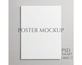 Könnte beinhalten: Ein weißes Poster-Mockup vor grauem Hintergrund. Der Text "POSTER MOCKUP" befindet sich zentriert oben, mit "PSD SMART OBJECT" unten rechts. Das Bild ist ein klares, minimalistisches Design, geeignet für die Präsentation von Kunstwerken oder Designs.
