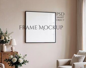 Könnte beinhalten: Ein schwarzer, quadratischer Kunstdruck-Mockup mit dem Text "FRAME MOCKUP" und "PSD SMART OBJECT" an einer hellrosa Wand. Der Raum ist mit einem Holzschrank, Blumen, einer Lampe, einem runden Couchtisch und einem beigen Sessel eingerichtet.