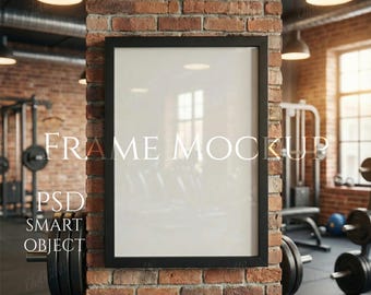 Könnte beinhalten: Ein schwarzer Rahmen-Mockup mit dem Text "FRAME MOCKUP" und "PSD SMART OBJECT" auf einer Ziegelsäule in einem Fitnessstudio. Das Fitnessstudio verfügt über Trainingsgeräte und Gewichte.