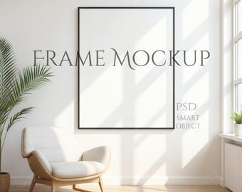 Könnte beinhalten: Ein schwarzer gerahmter Kunstdruck-Mockup mit dem Text "FRAME MOCKUP" in einem hellen Raum. Ein moderner Stuhl und eine Topfpflanze befinden sich im Vordergrund. Das Bild enthält auch den Text "PSD SMART OBJECT".