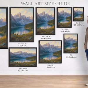 Puede incluir: Una gu&iacute;a de tama&ntilde;os de arte mural muestra pinturas de paisajes enmarcadas. Las pinturas representan una escena de lago de monta&ntilde;a con varios tama&ntilde;os, incluyendo 61 x 91 cm, 51 x 76 cm, y opciones m&aacute;s peque&ntilde;as. Una mujer est&aacute; de pie junto a la exhibici&oacute;n.