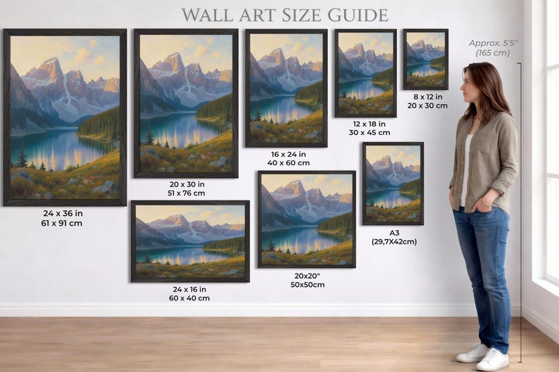 Puede incluir: Una gu&iacute;a de tama&ntilde;os de arte mural muestra pinturas de paisajes enmarcadas. Las pinturas representan una escena de lago de monta&ntilde;a con varios tama&ntilde;os, incluyendo 61 x 91 cm, 51 x 76 cm, y opciones m&aacute;s peque&ntilde;as. Una mujer est&aacute; de pie junto a la exhibici&oacute;n.