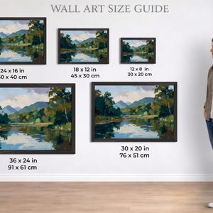 Puede incluir: Gu&iacute;a de tama&ntilde;os de arte mural con pinturas de paisajes enmarcadas. Las pinturas representan una serena escena de r&iacute;o con monta&ntilde;as y &aacute;rboles. Los tama&ntilde;os var&iacute;an de 30 x 20 cm a 91 x 61 cm. Una mujer est&aacute; de pie junto a la exhibici&oacute;n, de aproximadamente 165 cm.